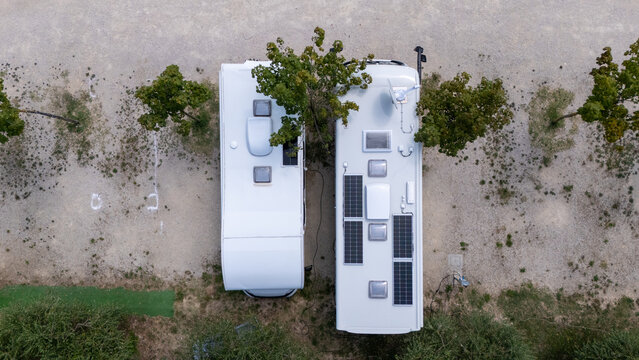 Aerial View of Camper Van Roof with Solar Panels Amid Trees