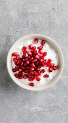 A bowl is filled with creamy coconut milk and adorned with juicy, bright red pomegranate seeds. The combination offers a light, healthy and visually striking treat
