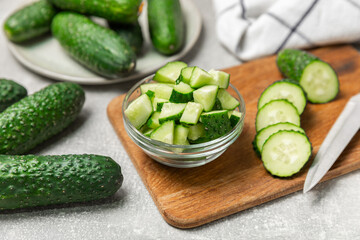 Cucumber on wooden background. Slice of cucumber on background. Fresh organic green cucumbers gherkin. Vegan. Salad ingredient. Farm vegetables. Cut vegetables with knife. Space for text. Copy space
