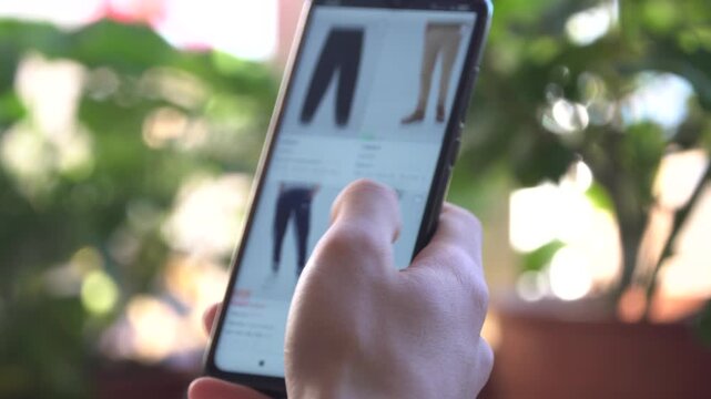 Online shopping. Buying trousers on the marketplace online, fast fashion