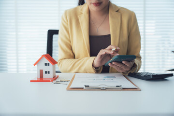 Real Estate Professional at Work: A professional, meticulously calculating figures at a desk...