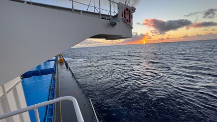 Stunning sunset view from the deck of a cargo ship with dramatic sky and ocean waves. Suitable for travel, maritime, or adventure themes. © Mariia