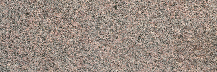 Granite texture. Natural pink granite with a grainy pattern. Stone background. Solid rough surface of rock. Durable construction and decoration material. Close-up.