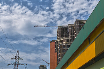 Construction site under a clear blue sky with cranes in the background