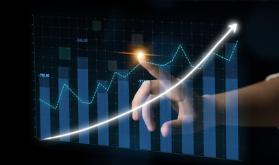 Naklejka na ściany i meble A hand reaches towards a digital graph showcasing financial growth. The upward trend and bright arrow symbolize positive market performance and data analysis. Impute