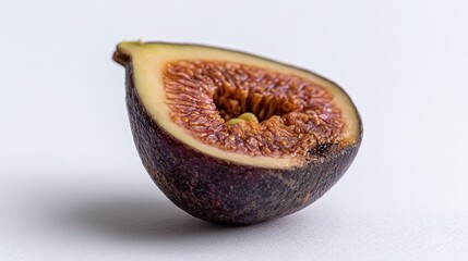 Fresh fig cut in half showing seeds and flesh on white background