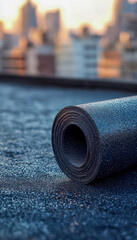Rubber exercise mat rolled out on rooftop with city skyline background at dusk