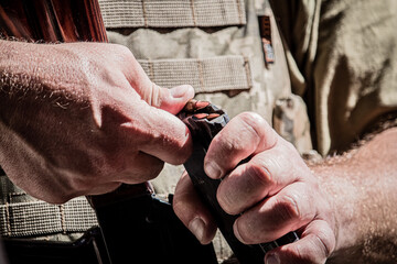 A man loads a machineA man loads a machine gun magazine with cartridges. magazine with cartridges.