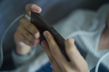 A smartphone in a horizontal position in the hands of a child. Child's hands playing a game on smartphone. High quality photo