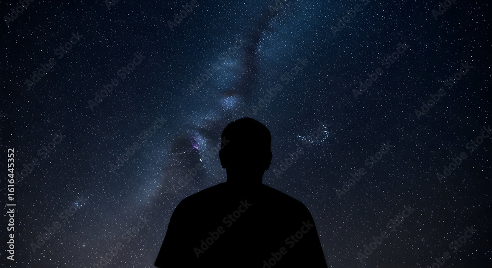 Wall mural silhouette of a person gazing at a stunning starry night sky with the milky way galaxy visible in th