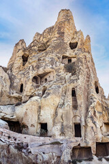 Fototapeta premium Hand carved rooms in unusual rock formation in Goreme, Cappadocia, Turkey Old houses constructed inside many caves inside mountains created by lava flows. 