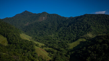 Obraz premium Aerial view of a mountainous and preserved region of the Atlantic Forest, a tropical rainforest in Rio de Janeiro, Brazil. The beauty and biodiversity are the highlights.