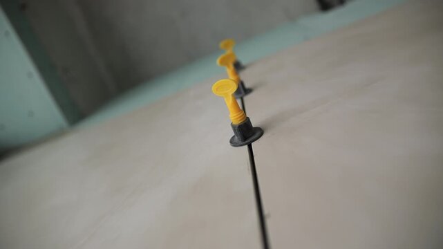 Tile leveling system between ceramic slabs on wall