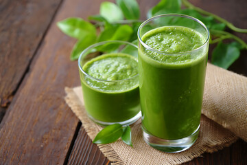 Fototapeta premium Fresh Green Smoothies in Glasses on Rustic Wooden Surface Representing Natural Health and Detox Lifestyle