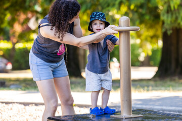 Mother Helps Toddler Boy Play Outside in Burnaby, Vancouver, BC, Canada