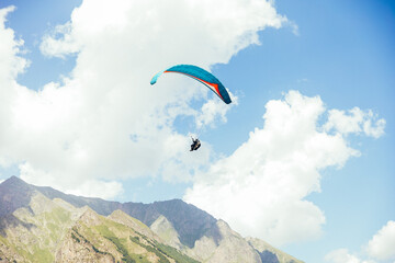 Paragliding against the backdrop of a clear blue sky and mountains.Papraplans in Chegem,...