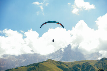 Paragliding against the backdrop of a clear blue sky and mountains.Papraplans in Chegem,...