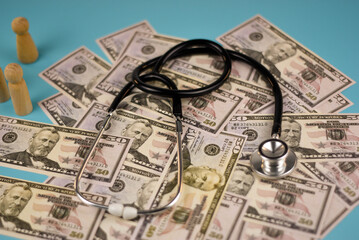 Wooden letter blocks spelling out "income tax" rest on a bed of US dollar bills.