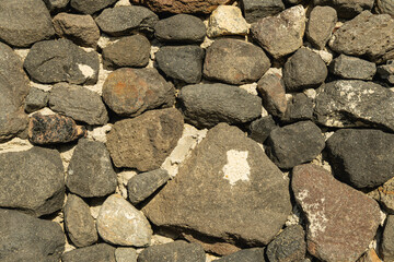 Textures variées d'une muraille en pierre issue de la nature exposée au soleil dans un environnement extérieur.