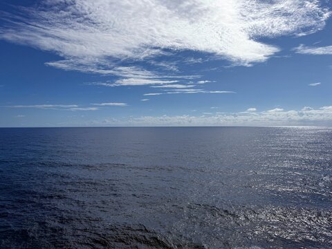 Blue shining ocean, sky and clouds.