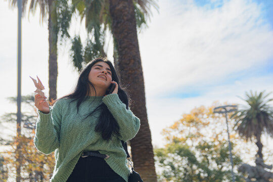 Young Venezuelan woman entertained talking on the phone outdoors