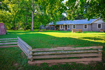 A small park with picnic tables alongside historic buildings along the main street of the rural village of Leiper's Fork, Tennessee.