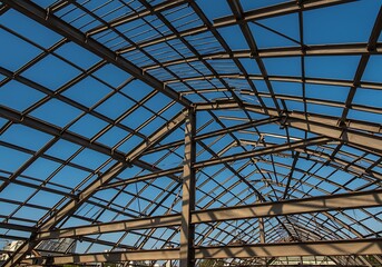 Looking Up at Steel Structure Framework Against Clear Blue Sky
