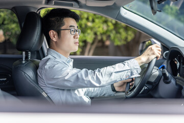 Man driving a car with focused expression on his face