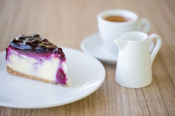 Cup of espresso coffee with a slice of blueberry cheese cake