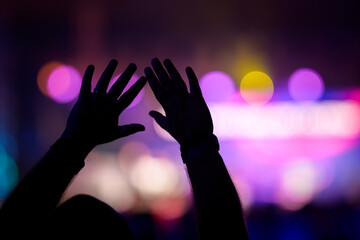 hands reaching for heaven praising Jesus during worship service