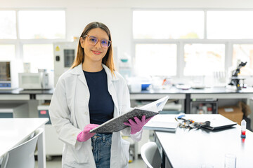 Female lab technician with notebook in modern laboratory