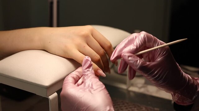 Nail care procedure in a beauty salon. Female hands and tools for manicure, process of performing manicure in beauty salon. Concept spa body care. Gloved hands of a skilled manicurist cutting cuticles