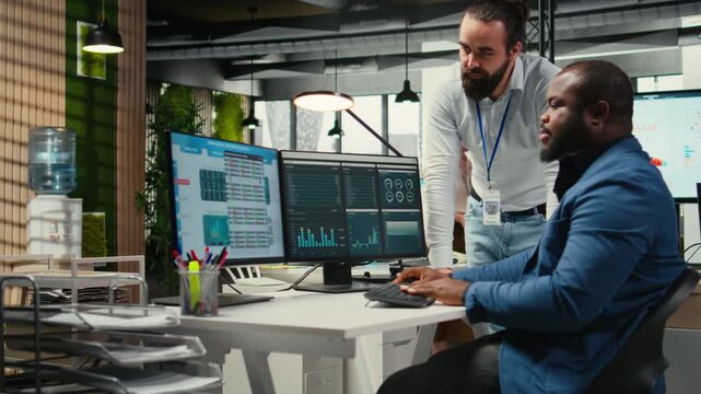 Diverse corporate team focuses on data management on computer, planning strategies for company growth and aligning objectives with performance metrics for measurable productivity. Camera A.