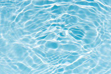 Blue water with ripples on the surface. Defocus blurred transparent blue colored clear calm water surface texture with splashes and bubbles. Water waves with shining pattern texture background.