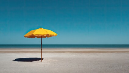 A solitary yellow beach umbrella on a pristine sandy shore under a vibrant blue sky