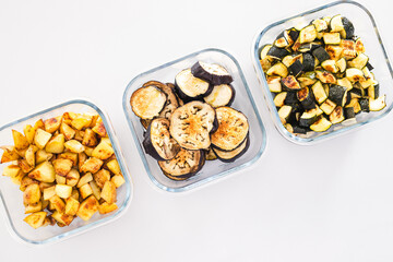 meal prep glass containers with roasted potatoes zucchini and eggplant slices