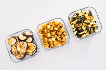 meal prep glass containers with roasted potatoes zucchini and eggplant slices