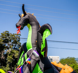 Large inflatable dragon with pride flags during outdoor city event