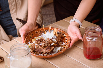 Unrecognizable waitress serving chilaquiles