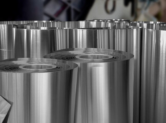 coils of aluminum metal material in a dark warehouse space