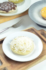 Serabi with grated cheese topping, a traditional Indonesian snack