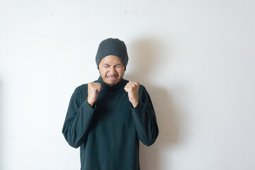Indonesian man wearing winter clothes feels annoyed