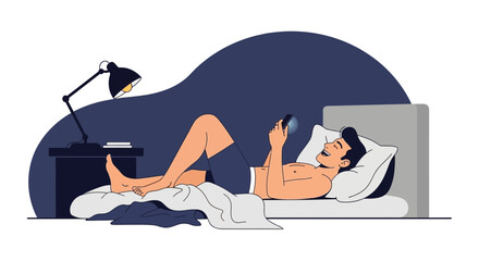 Fototapeta premium A relaxed man using a smartphone in bed at night with a bedside lamp providing light creating a cozy atmosphere