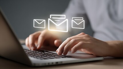 Person typing on laptop with email icons appearing above