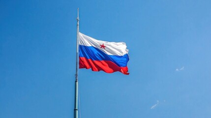 A large national flag waves proudly atop a tall flagpole against a clear blue sky during a patriotic ceremony in a city square