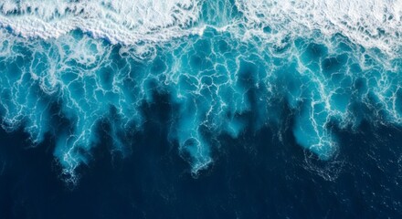 Fototapeta premium High-angle view of ocean waves crashing, showcasing vibrant turquoise water.