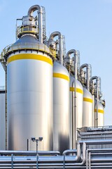 Fototapeta premium Industrial silos refinery with clear sky backdrop