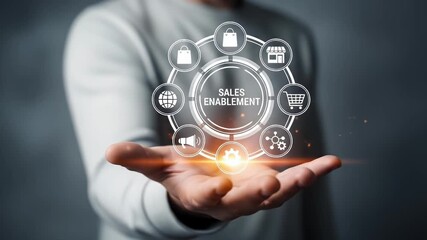 A person holding a sales enablement concept with icons floating above their open hand in a dark room - Powered by Adobe