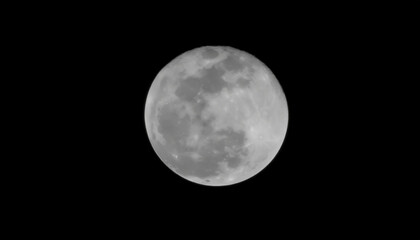 Fototapeta premium A clear view of the full moon, showcasing its craters and surface details against a black sky