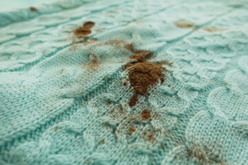 Sweater with dirt stains on light blue fabric